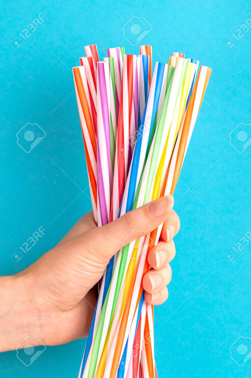 112694965-woman-is-holding-colorful-plastic-straws-in-hand-on-bright-background-event-and-part...jpg