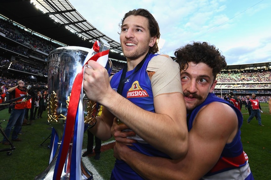 [PLAYERCARD]Marcus Bontempelli[/PLAYERCARD] holds the premiership cup as Tom Liberatore hugs him from behind