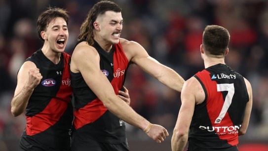 Essendon players celebrate on the fial siren.