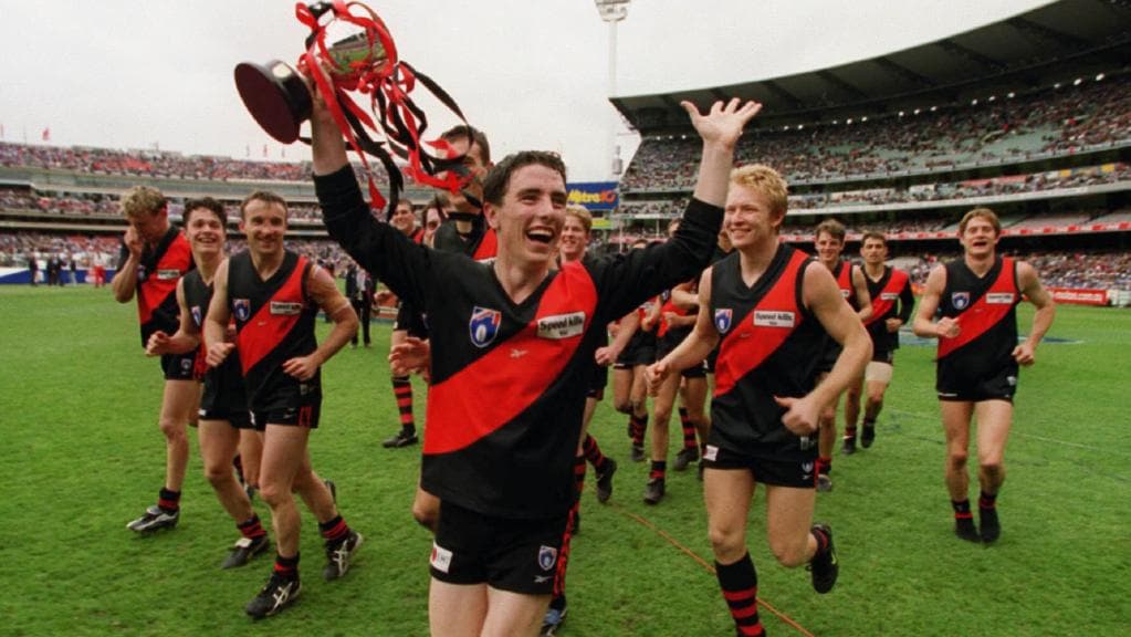 Essendon players, including Stephen Milne, celebrate after winning the 1999 reserves grand final.