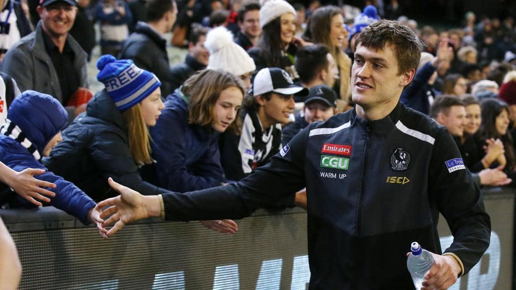 An injured Darcy Moore celebrates Collingwood’s Round 23 win with supporters. Picture: Michael Klein.