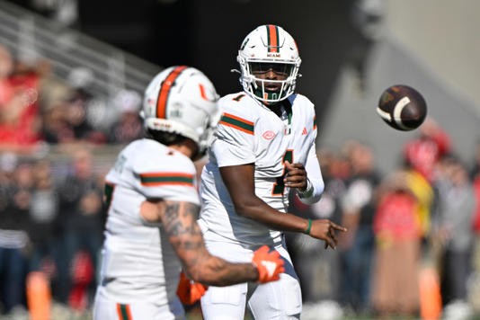 Oct 19, 2024; Louisville, Kentucky, USA; Miami Hurricanes quarterback Cam Ward (1) passes to wide receiver Xavier Restrepo (7) against the Louisville Cardinals during the first quarter at L&N Federal Credit Union Stadium. Mandatory Credit: Jamie Rhodes-Imagn Images