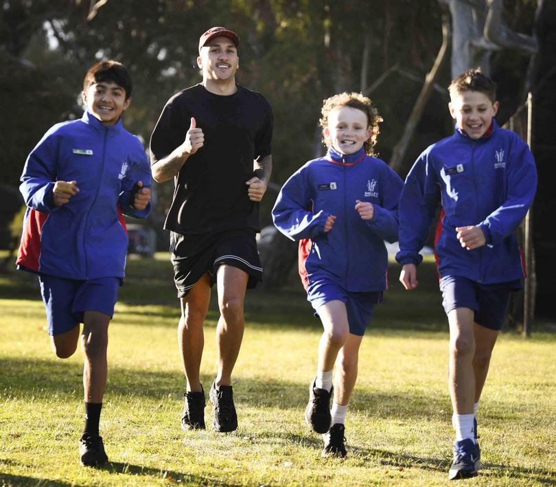 Education Minister Tony Buti launches his running challenge at Shelley Primary School. Pictured running with some children is Richmond player Shai Bolton.