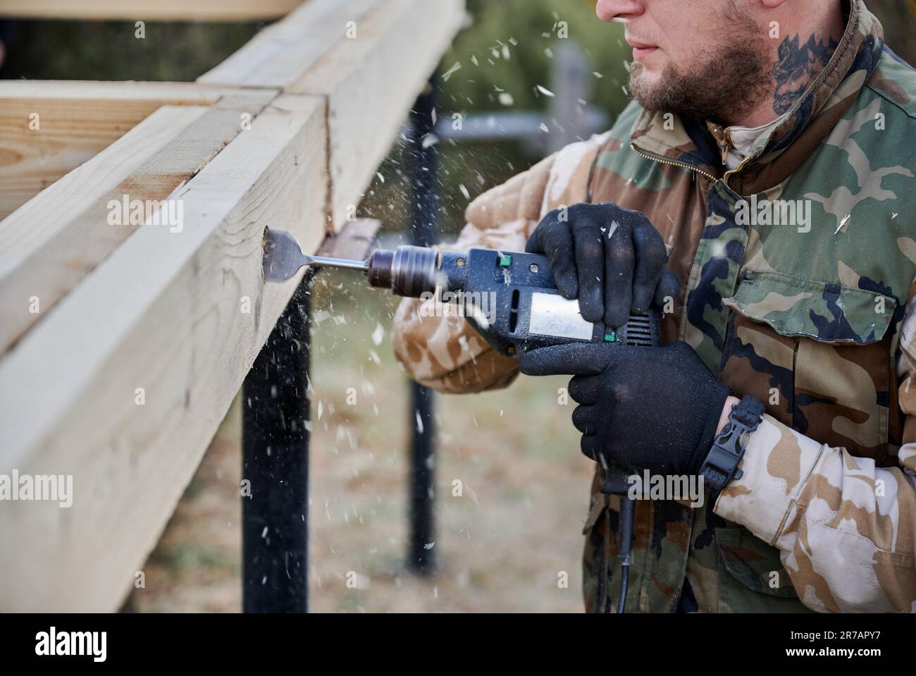 man-building-frame-house-on-pile-foundation-close-up-of-male-worker-drilling-hole-by-electric-drill-in-wooden-frame-of-future-house-on-construction-site-carpentry-concept-2R7APY7.jpg