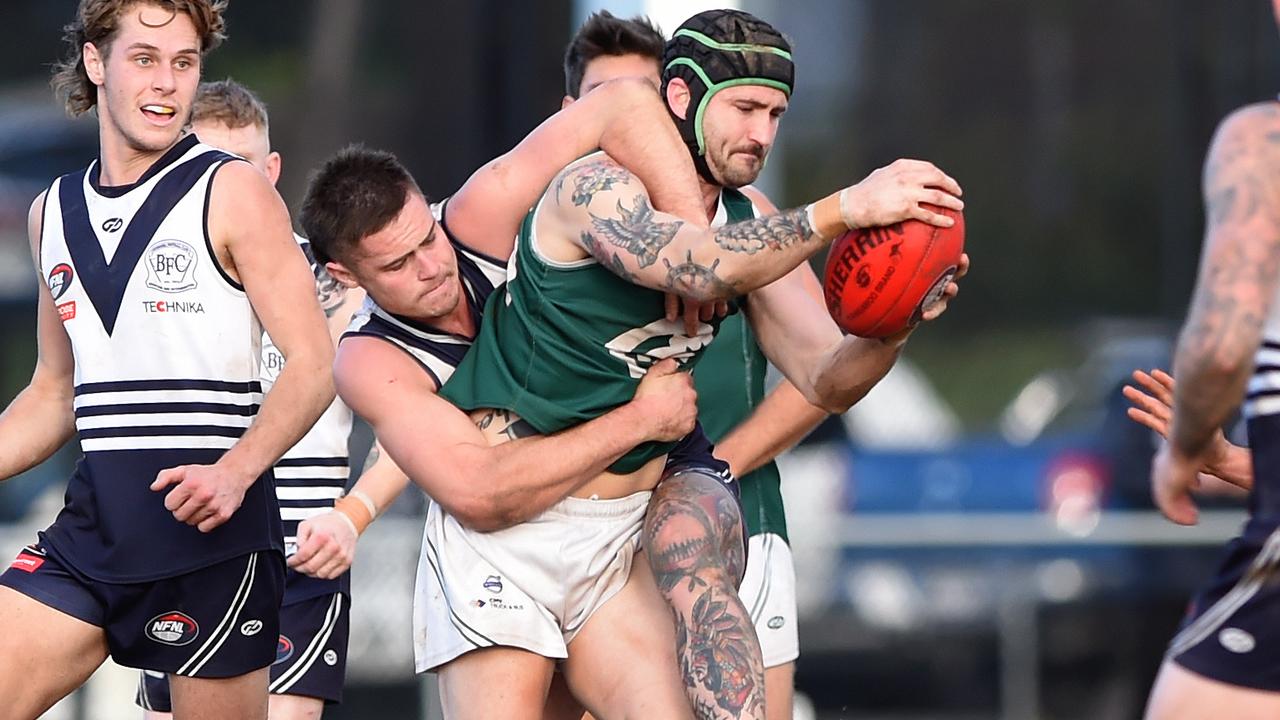 Greensborough champion Chris Clark fights off the tackle. Picture: Steve Tanner