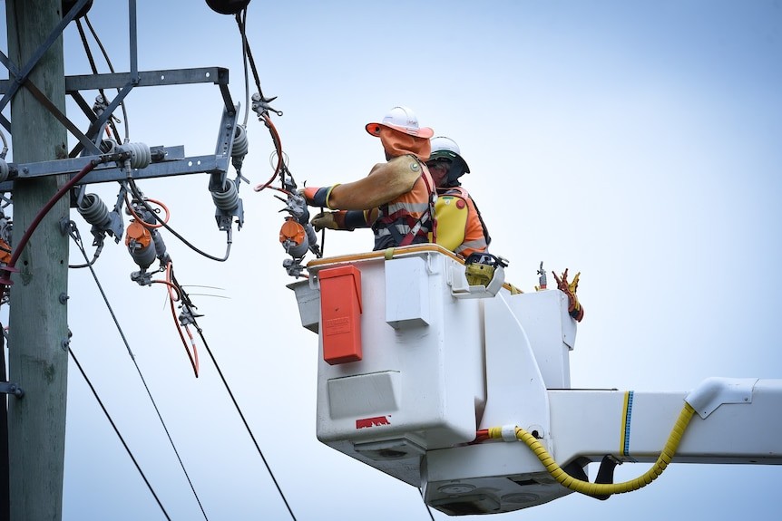 Two workers in Hi-Vis on a crane working on a powerline.