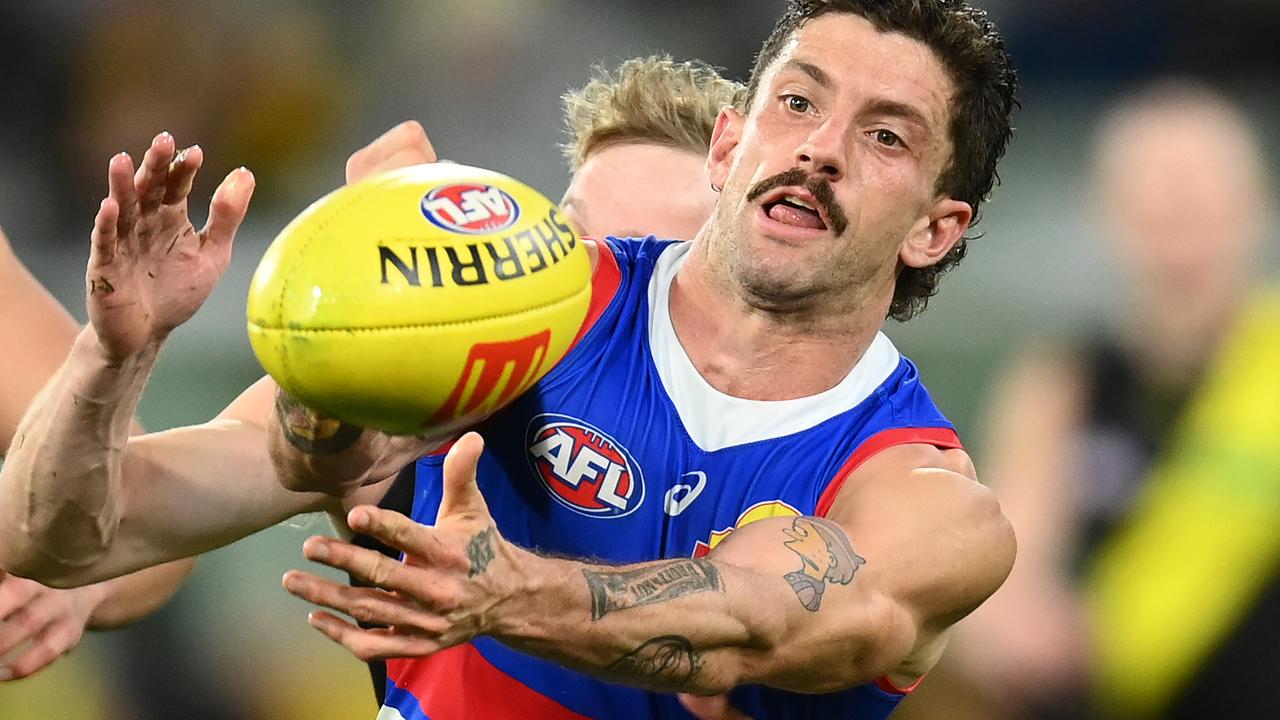 Tom Liberatore handballs as he is tackled at the MCG. Picture: Quinn Rooney/Getty Images