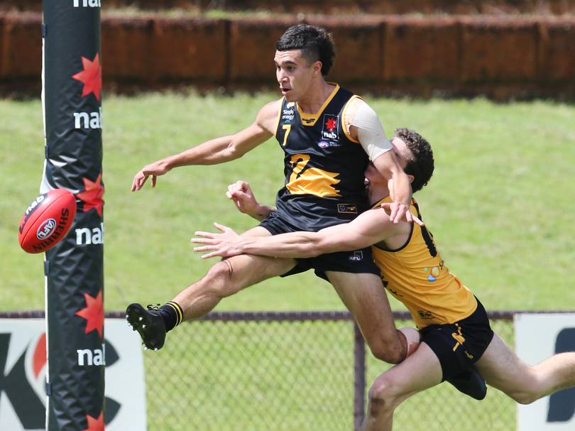 WA Black’s Tyler Brockman kicks a goal out of mid-air despite pressure from WA Gold player Tyler Nesbitt.