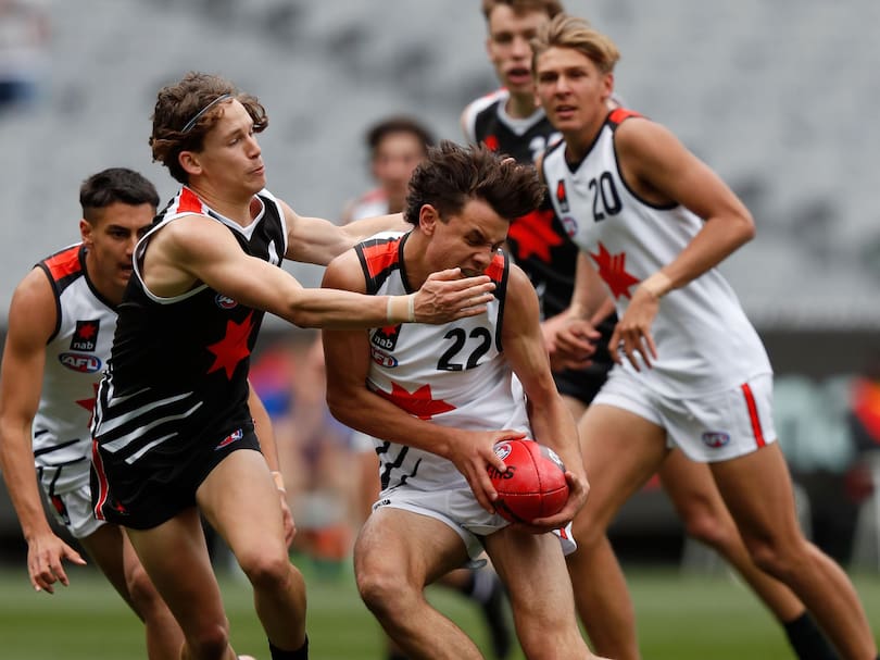 Heath Chapman tries to break a tackle during the AFL grand final curtain-raiser on the MCG.