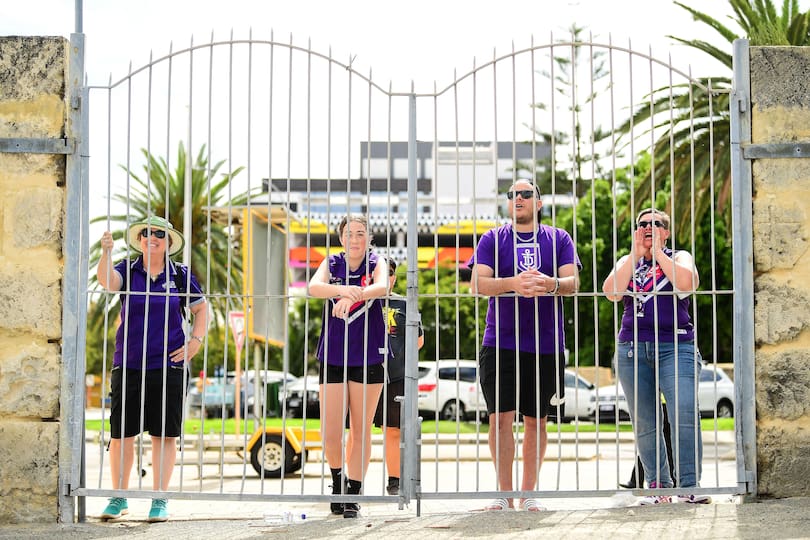 Locked out Fremantle fans cheers on through the fence during the 2020 AFLW Semi Final.